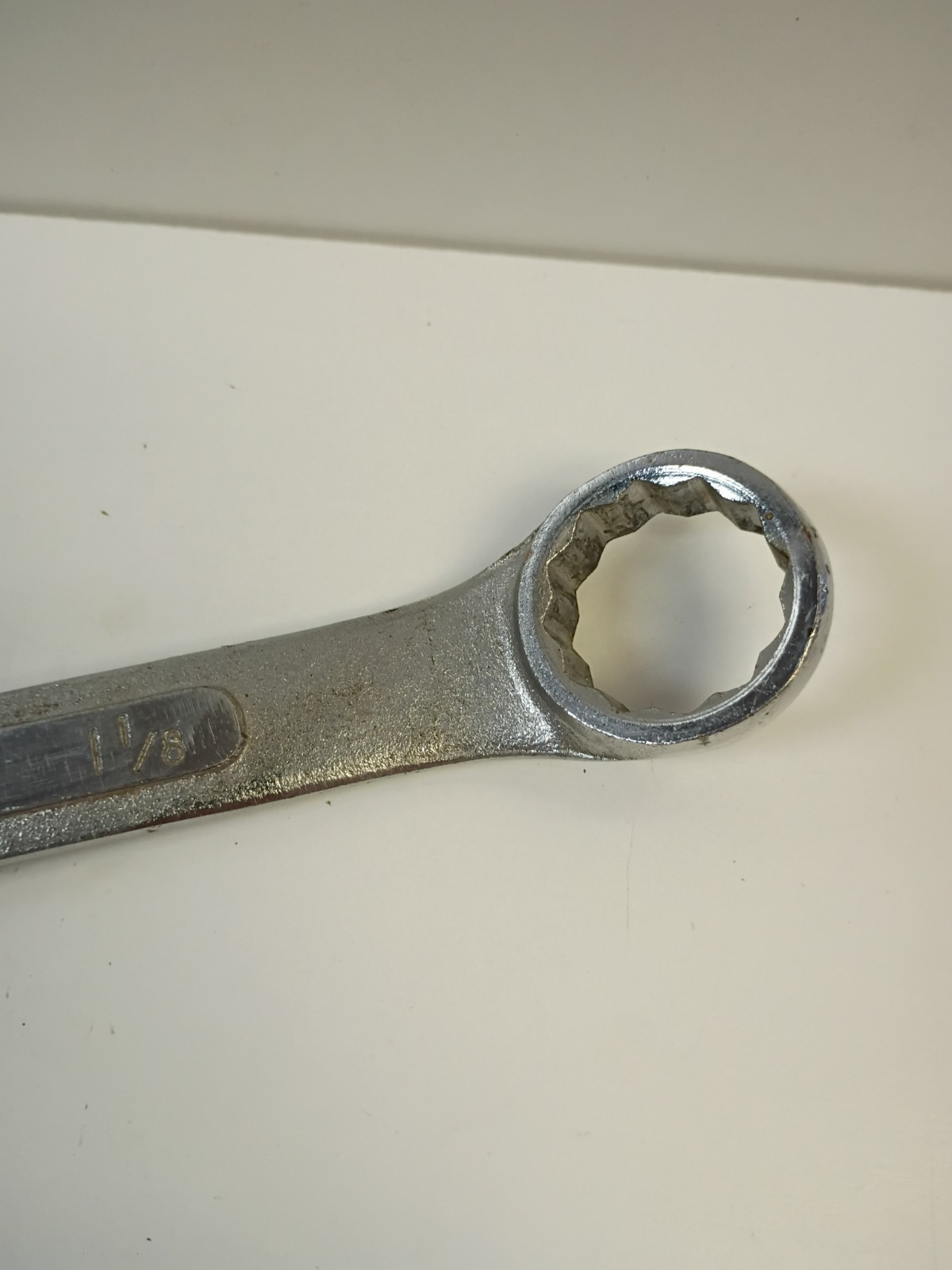 1-1/8-inch combination wrench featuring an open end and a 12-point box end