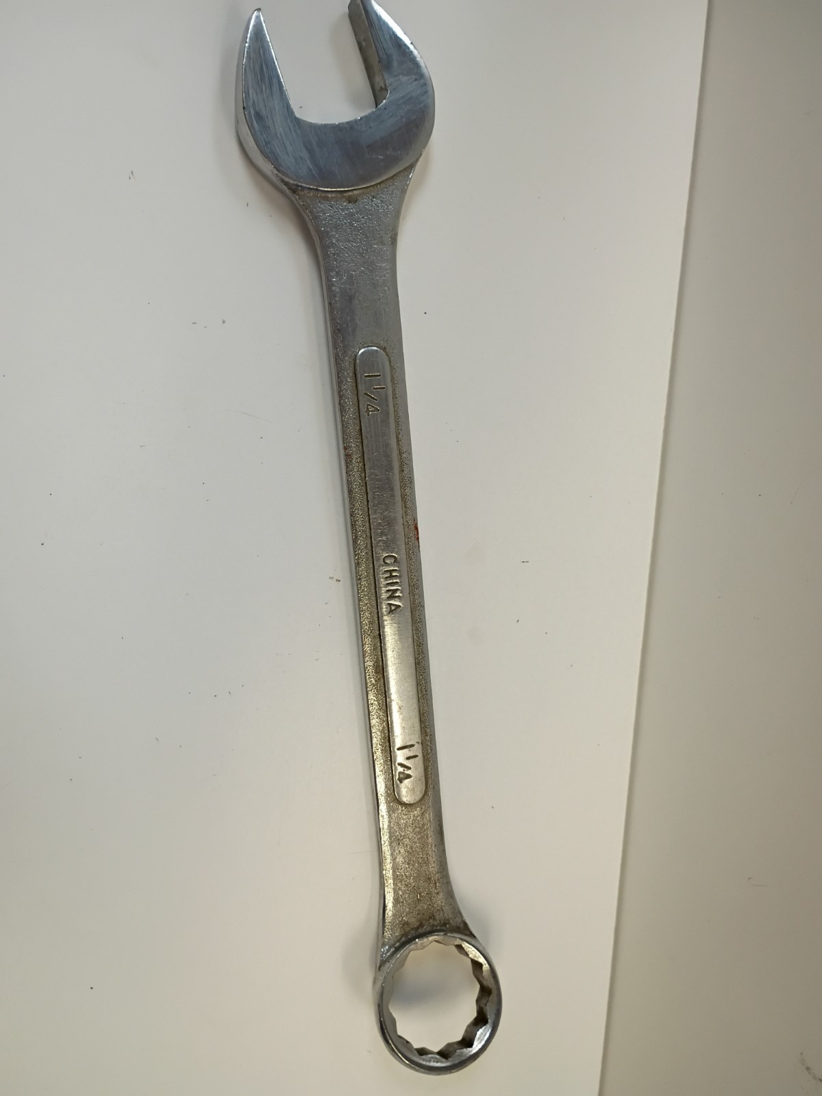 1-1/4-inch combination wrench featuring an open end and a 12-point box end