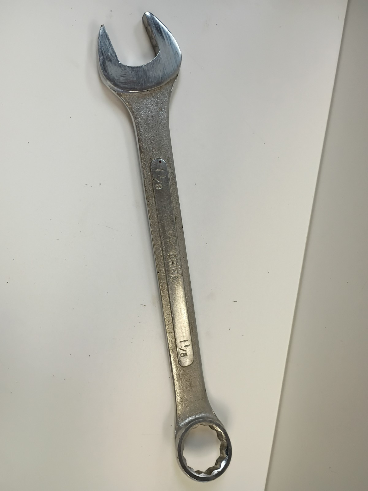 1-1/8-inch combination wrench featuring an open end and a 12-point box end