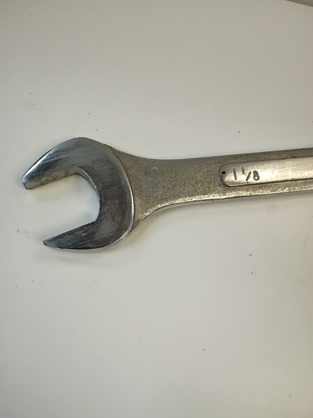 1-1/8-inch combination wrench featuring an open end and a 12-point box end
